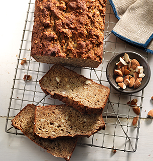 Protein Packed Banana Bread made with Astro Yogurt partially sliced on a cooling rack