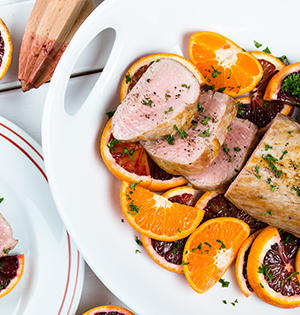 Yogurt and Orange Marinated Pork Tenderloin made with Astro Yogurt sitting on top of a bed of orange slices