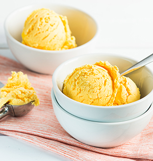 Honeyed Peach Frozen Yogurt made with Astro yogurt scooped into white dessert bowls